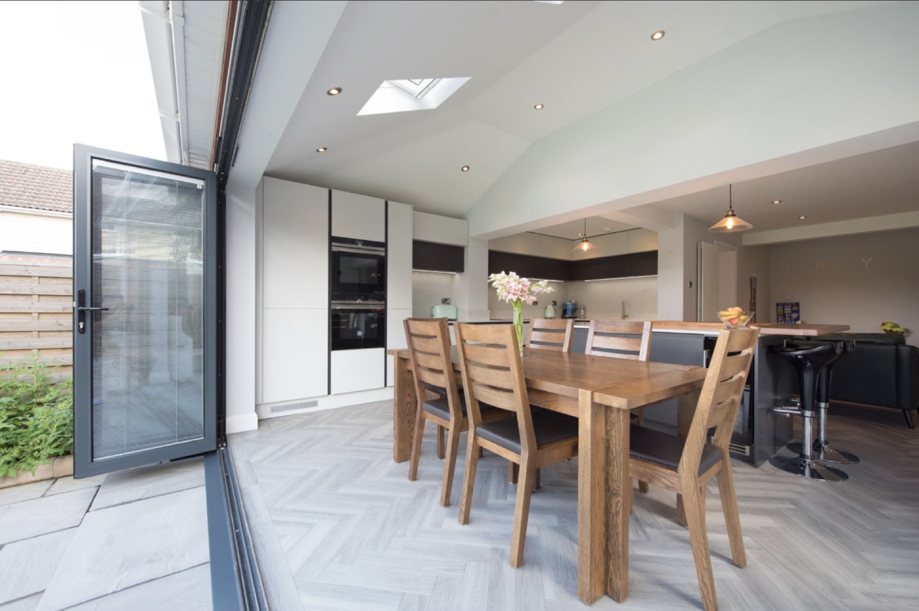 Open-plan kitchen and dining room with bi-fold doors open