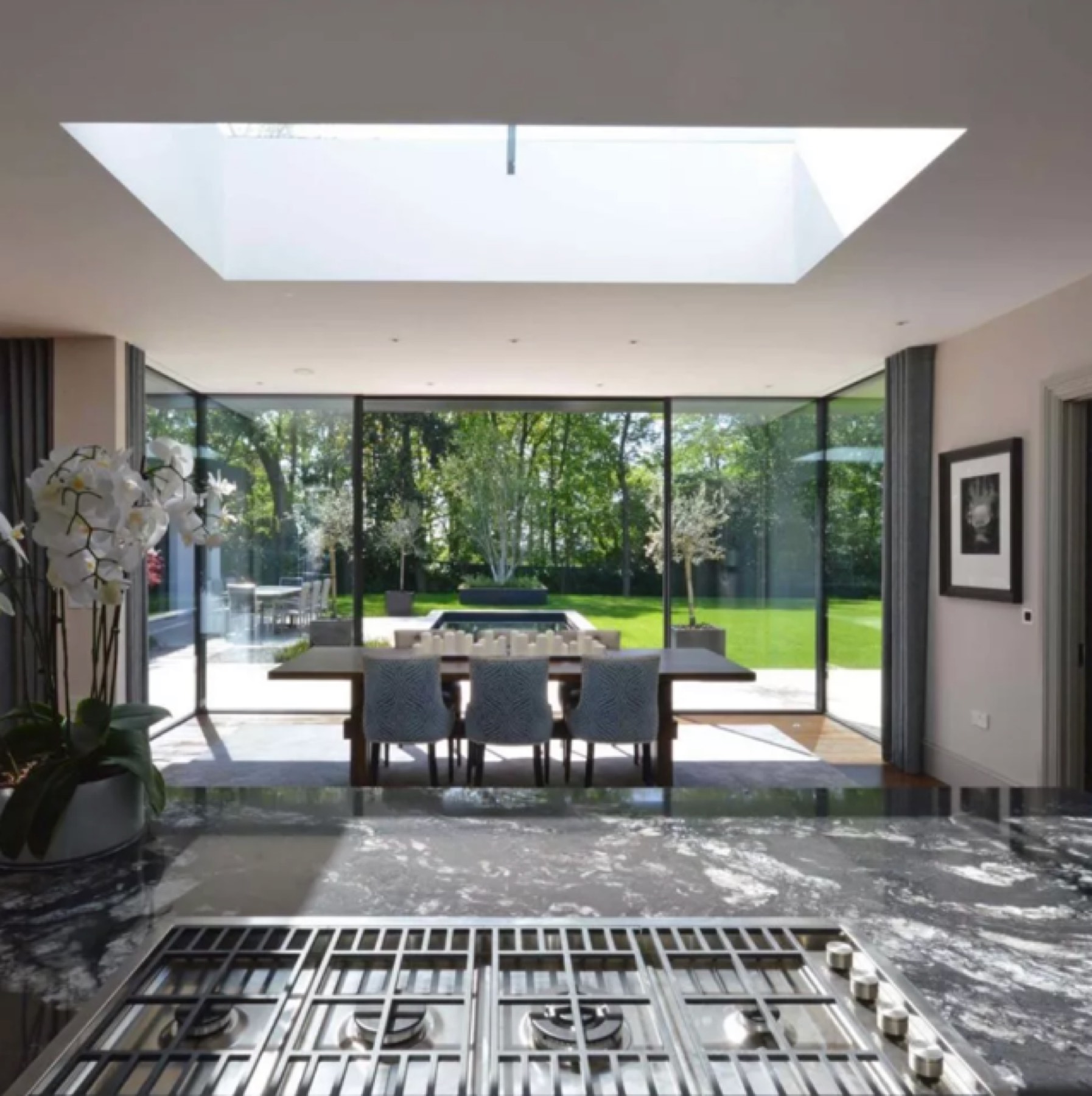 Dining area under a flush rooflight with full-height glazing to the garden