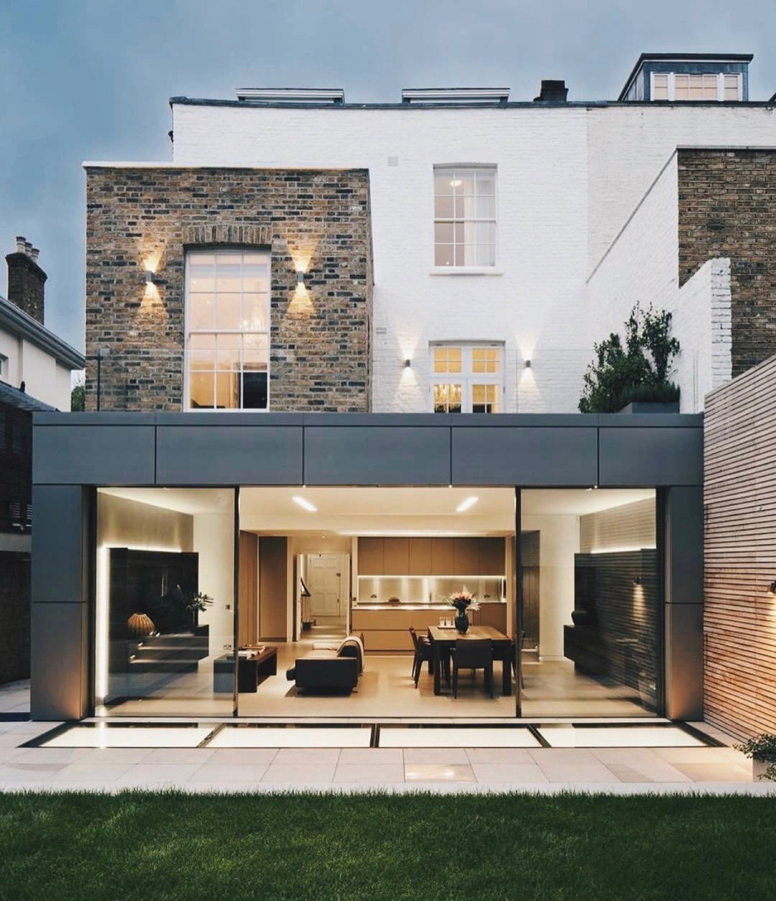 Rear extension lit from within at dusk, seen from the garden