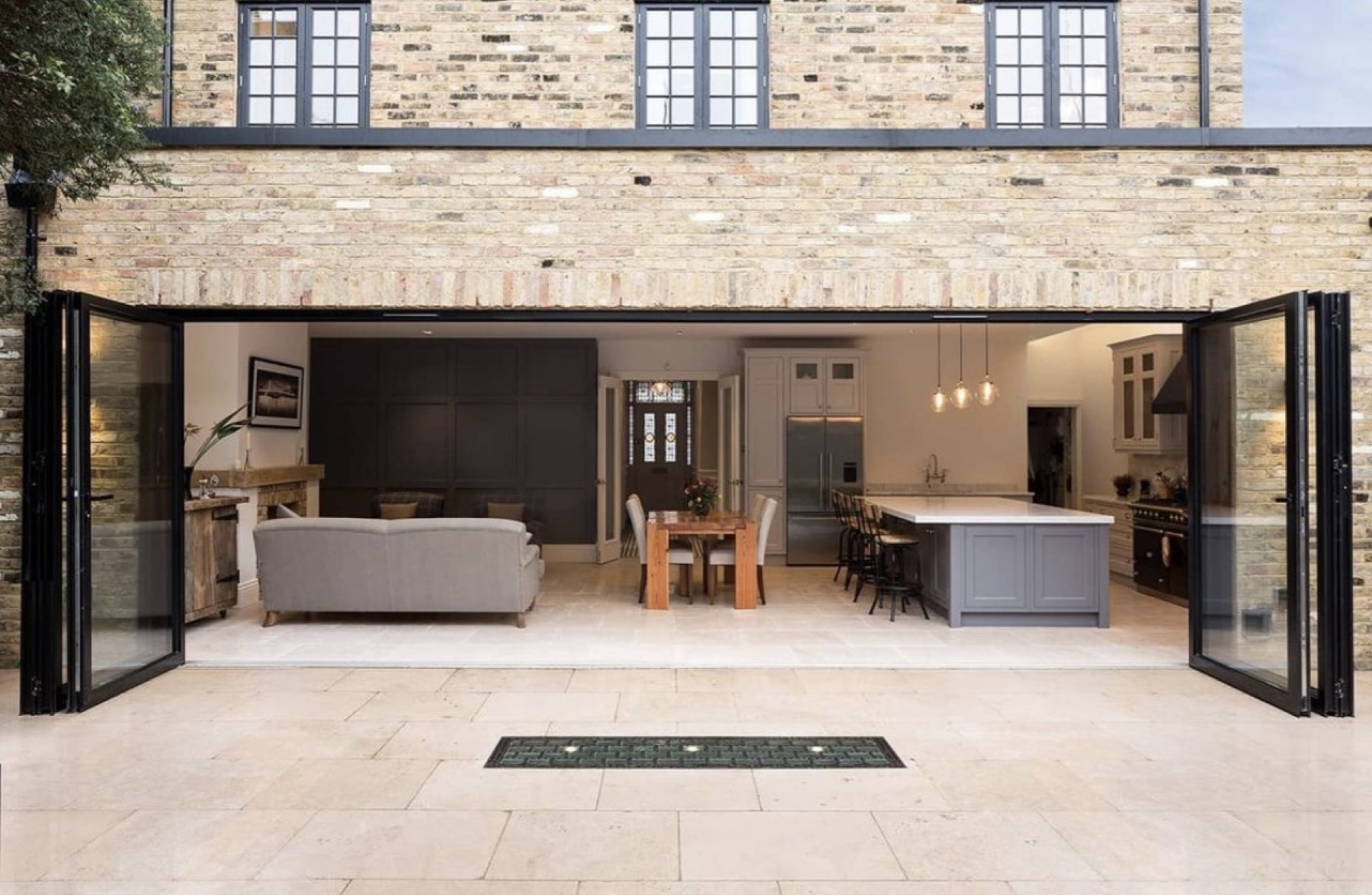 Wide bi-fold opening spanning the rear of a brick house